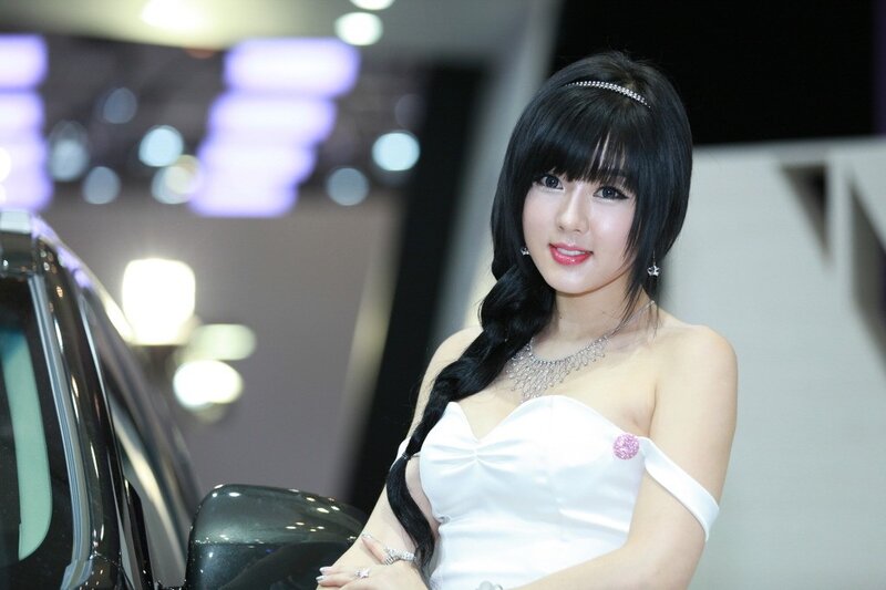 Woman in white dress at car show