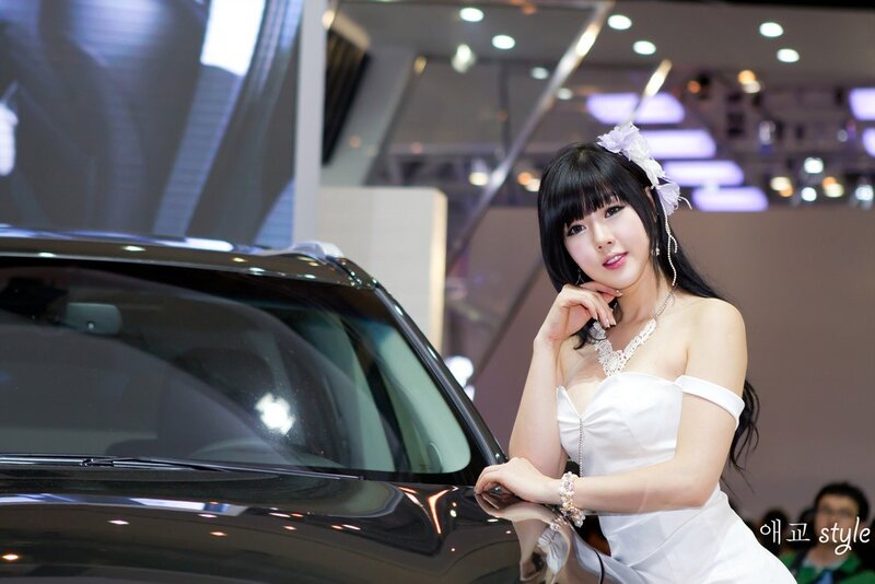 Woman in white dress at car show
