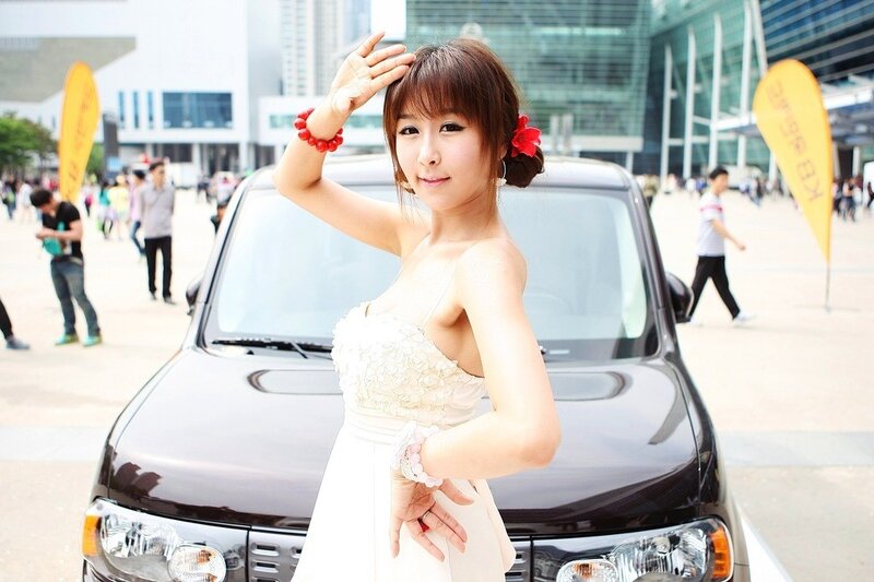 Woman in white dress at car show