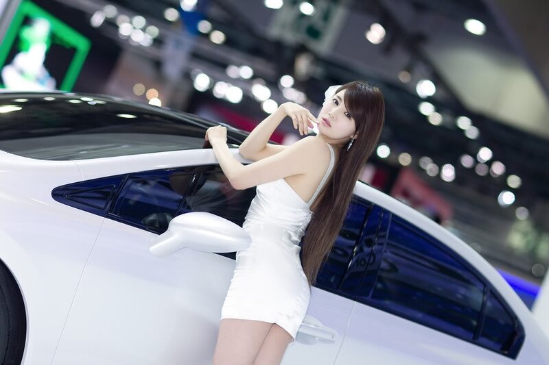 Woman in white dress at car show
