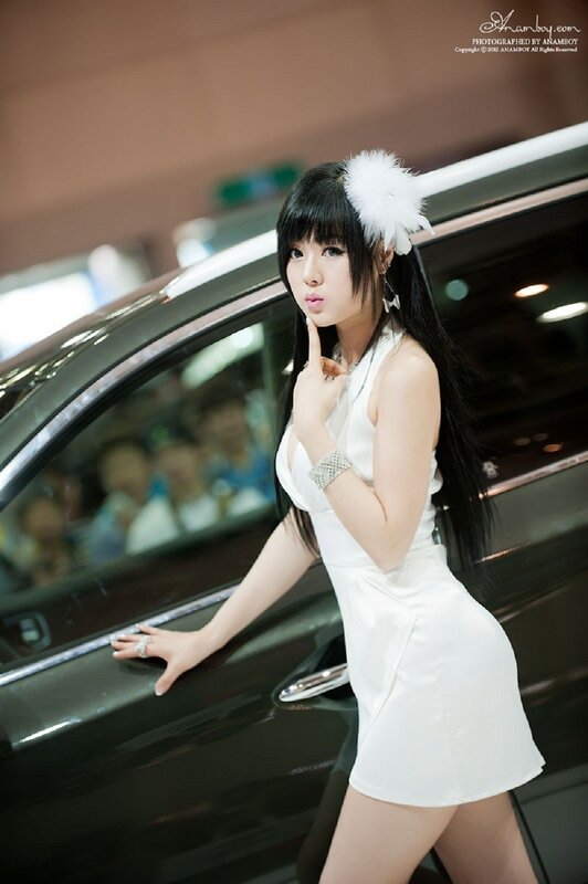 Woman in white dress at car show