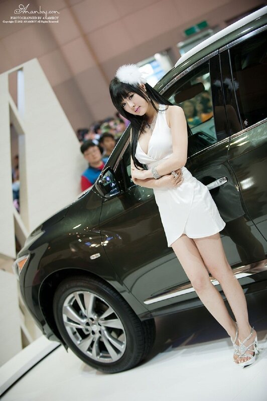 Woman in white dress at car show