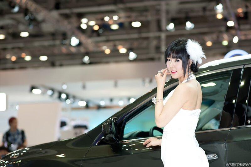 Woman in white dress at car show