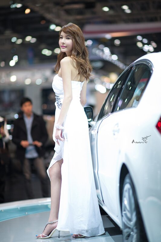Woman in white dress at car show