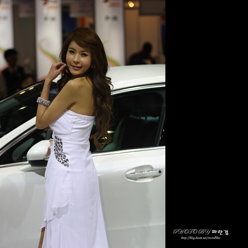 Woman in white dress at car show