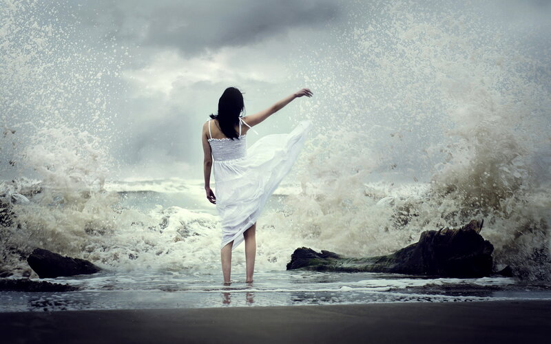 Woman in white dress at stormy beach