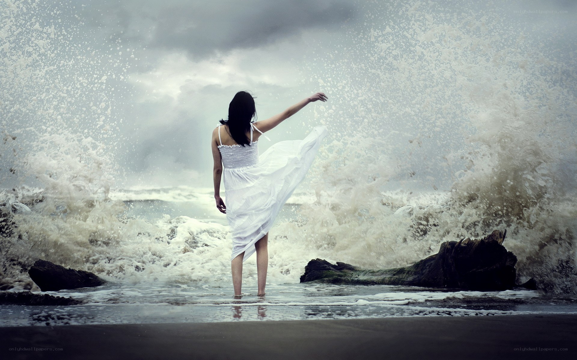 Woman in white dress at stormy beach