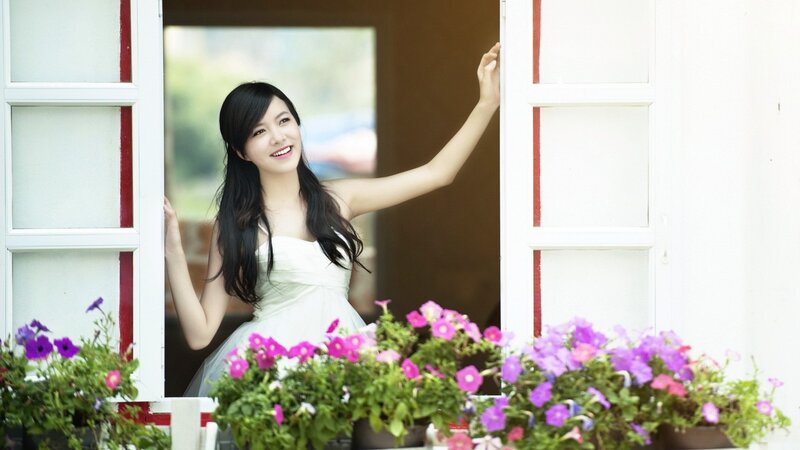 woman in white dress at window