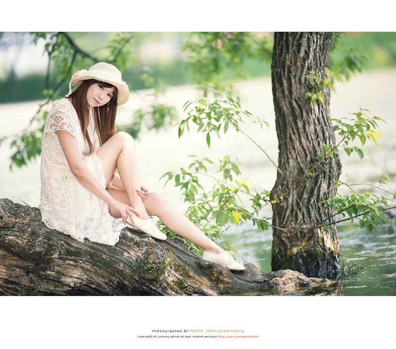 Woman in white dress by a tree