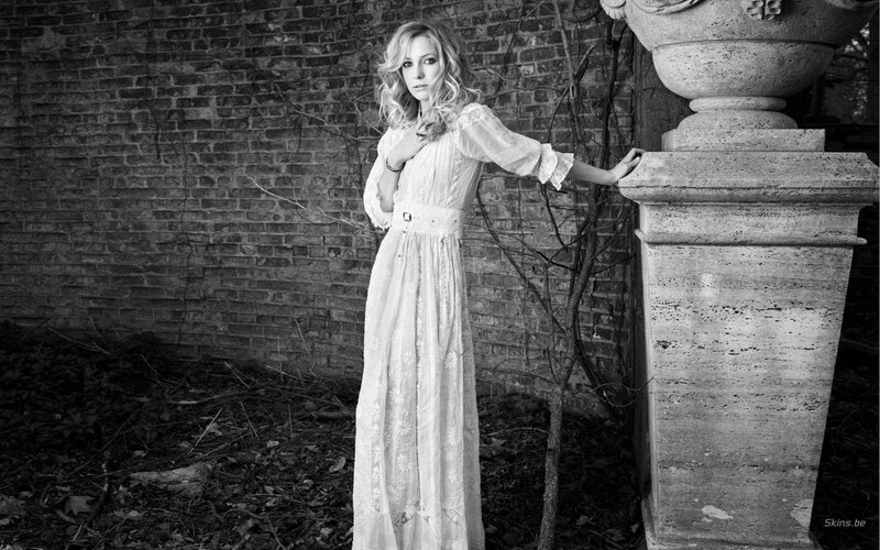 woman in white dress by brick wall