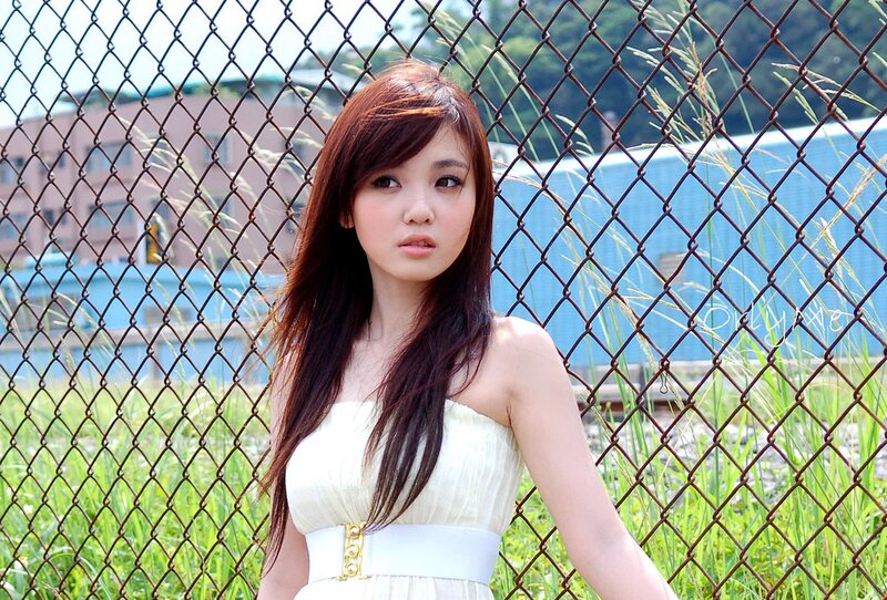 woman in white dress by fence