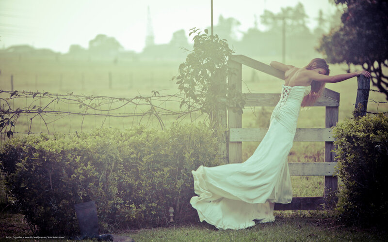 Woman in white dress by fence