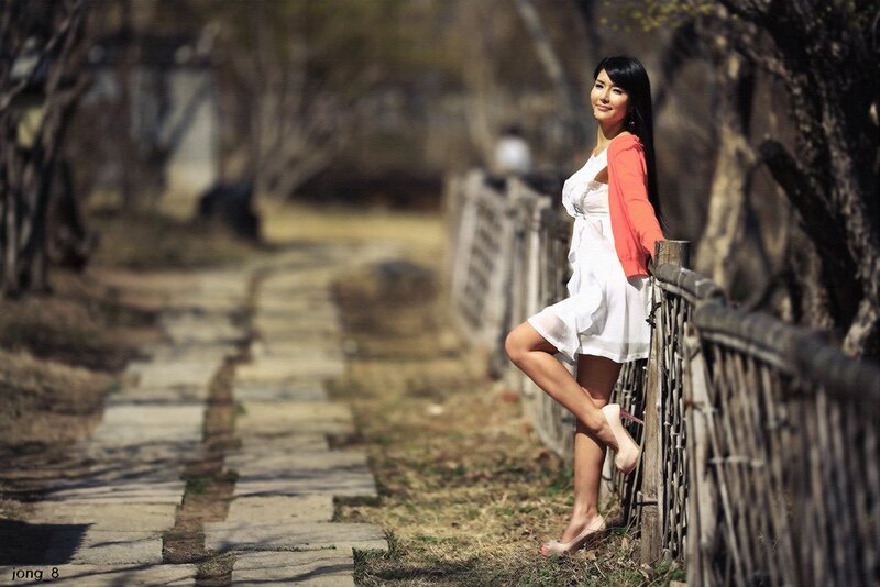 Woman in white dress by fence