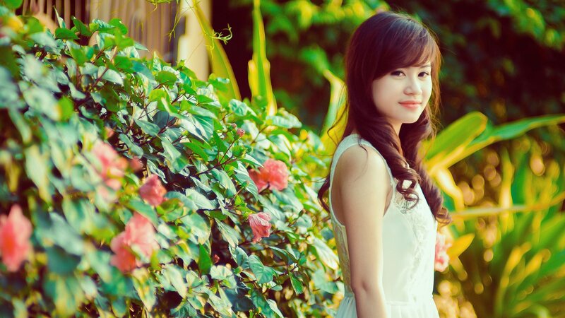 woman in white dress by flowers