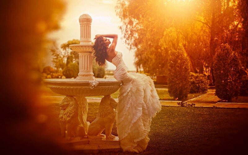 woman in white dress by fountain