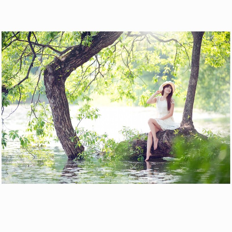 Woman in white dress by lake