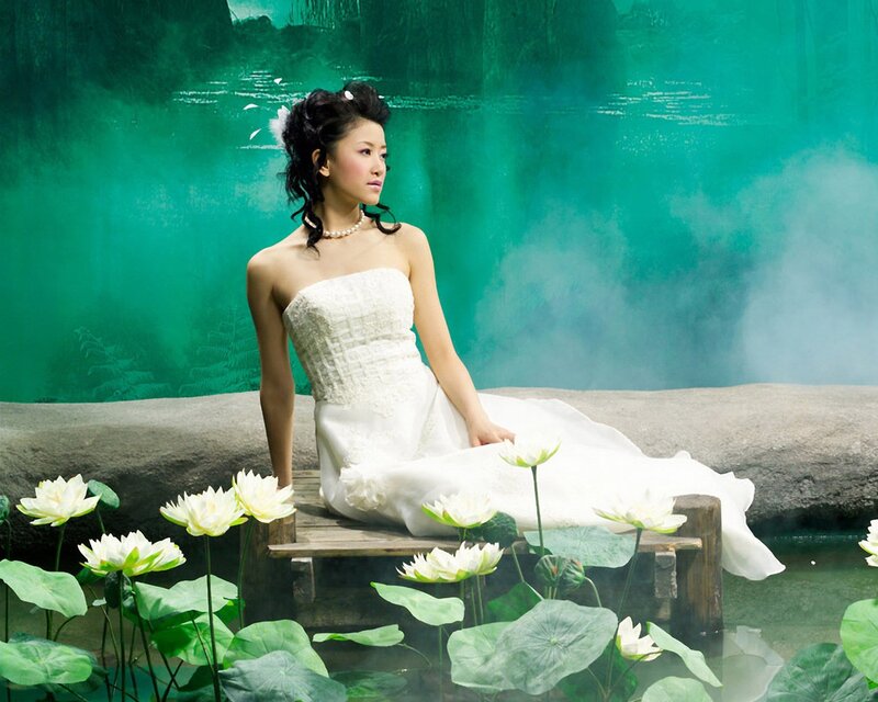 woman in white dress by lotus pond
