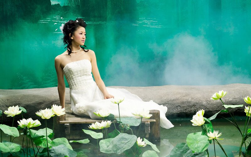 Woman in white dress by lotus pond