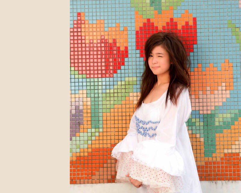 woman in white dress by mosaic wall