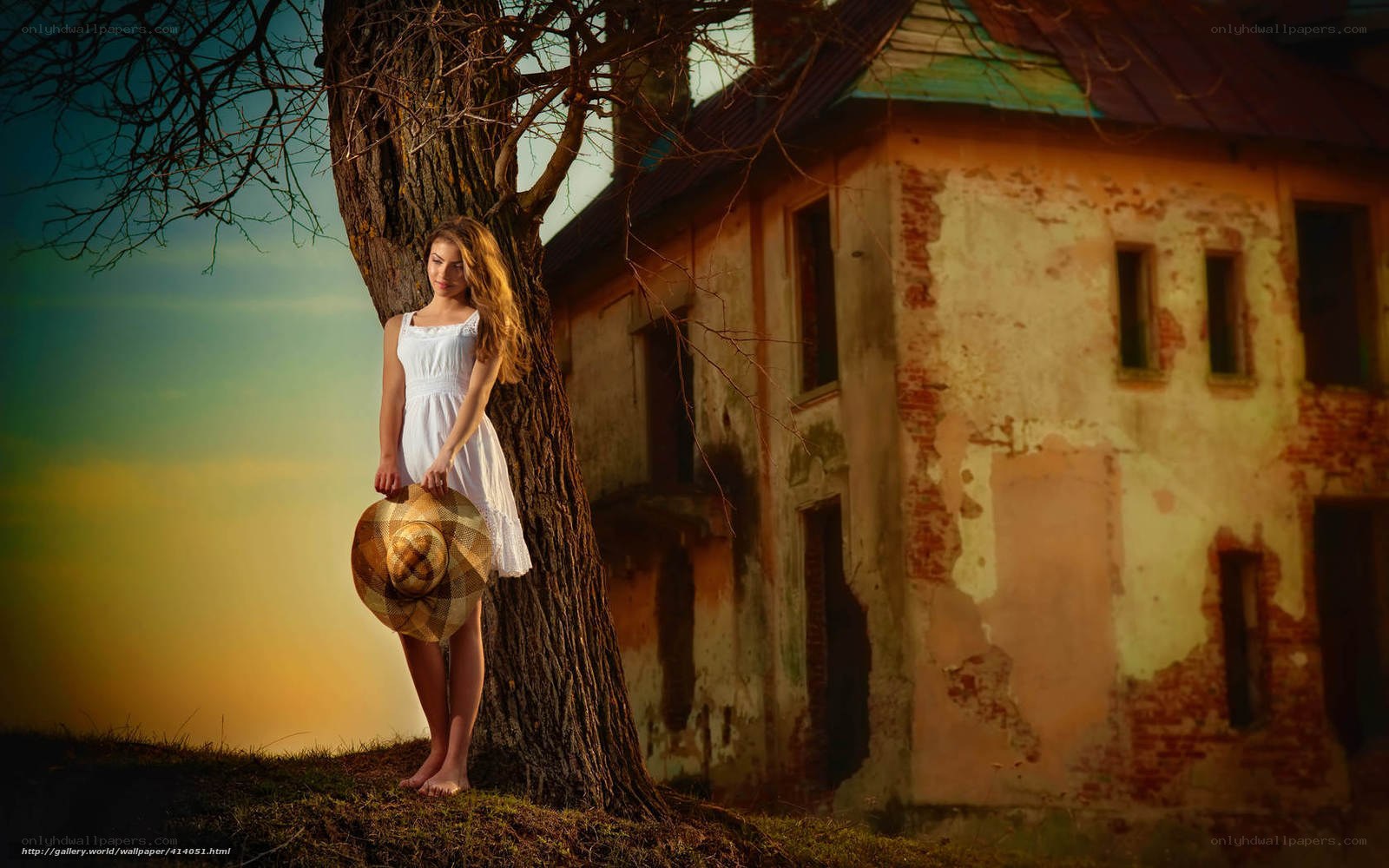 Woman in white dress by old house