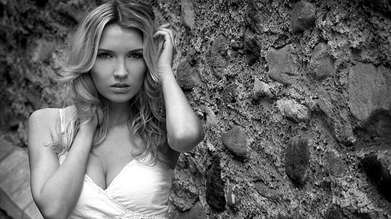 woman in white dress by stone wall