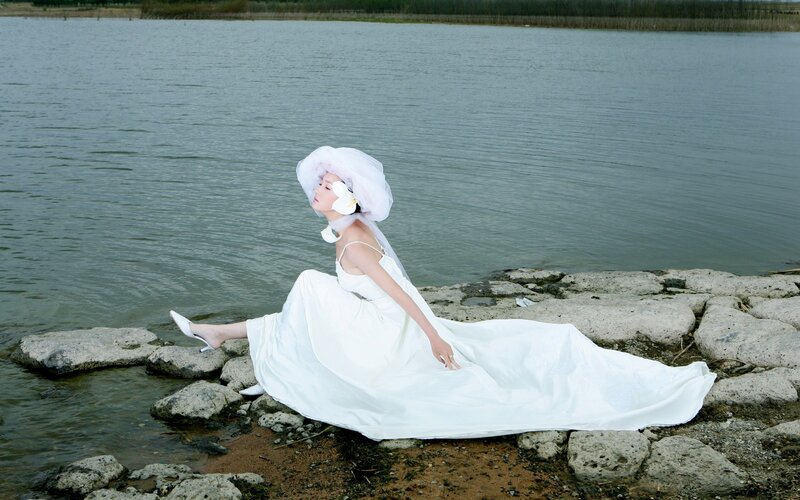 Woman in white dress by the water