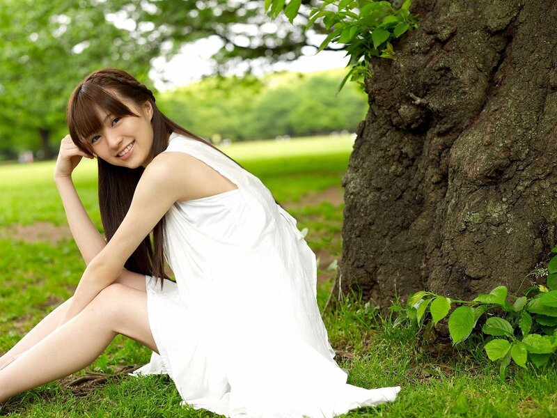 Woman in white dress by tree