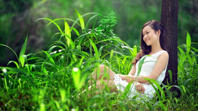 Woman in white dress by tree