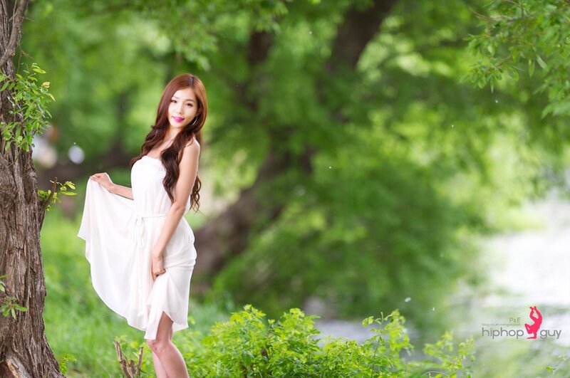 Woman in white dress by tree