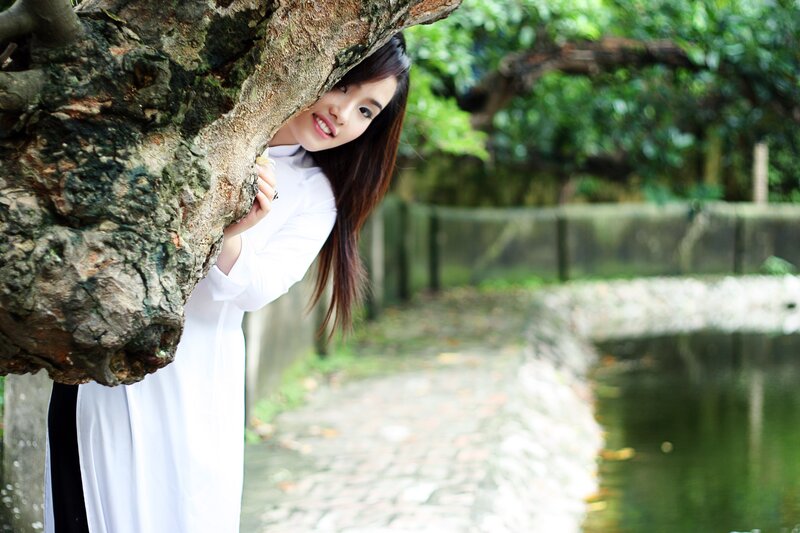 Woman in white dress by tree