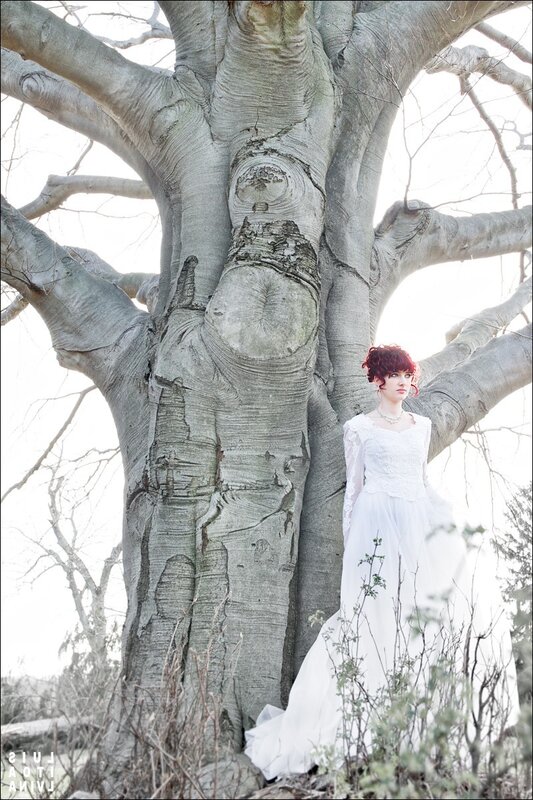 Woman in white dress by tree
