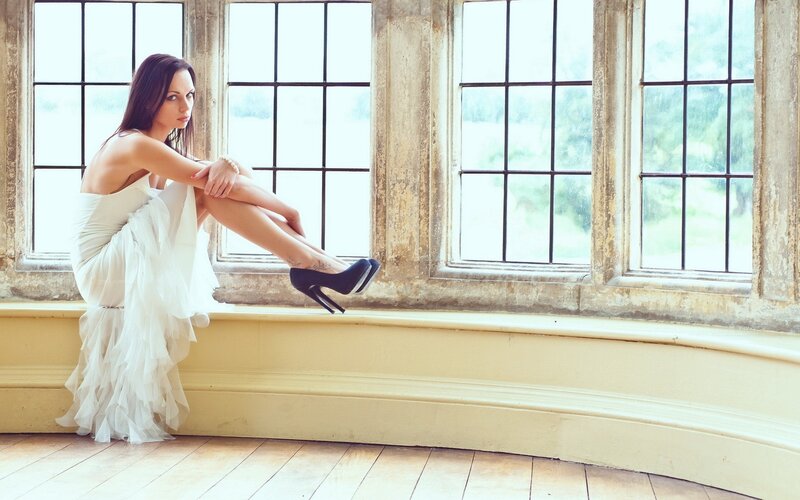 woman in white dress by window