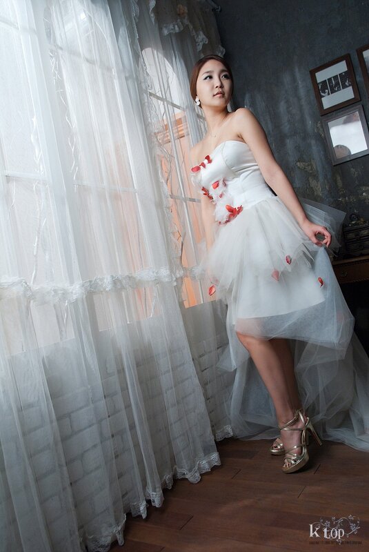 woman in white dress by window
