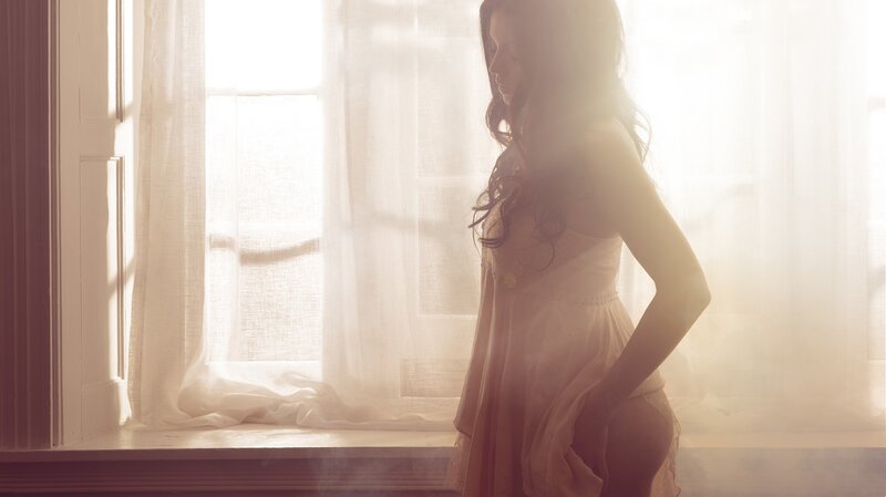 woman in white dress by window