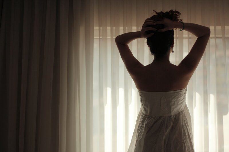 woman in white dress by window