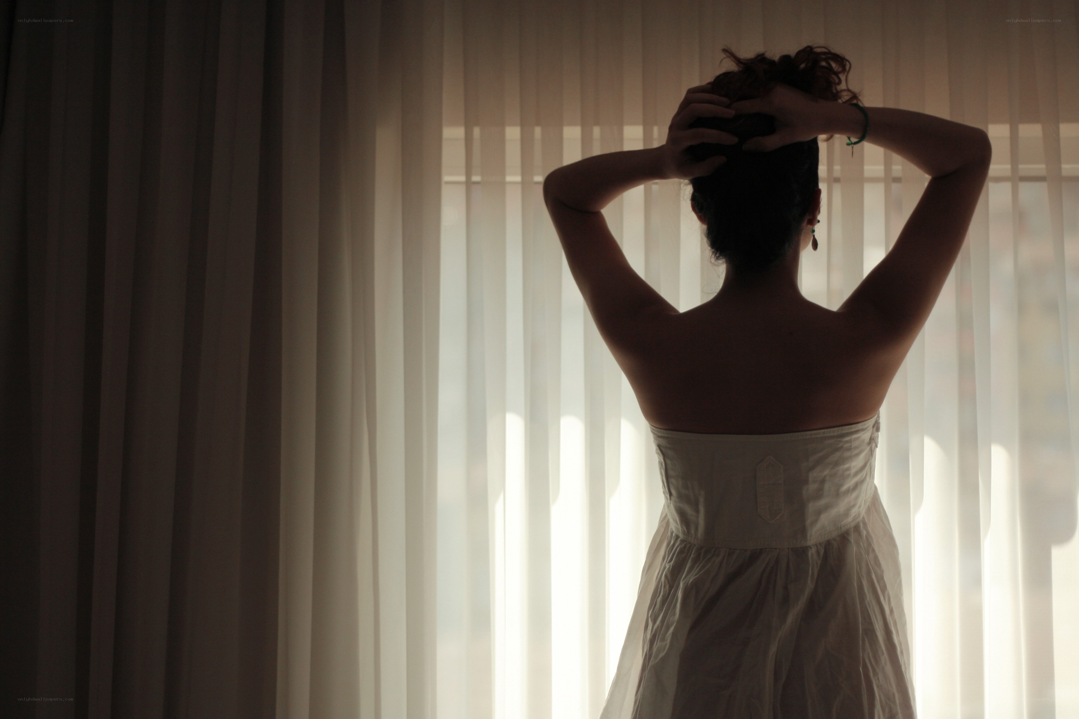woman in white dress by window