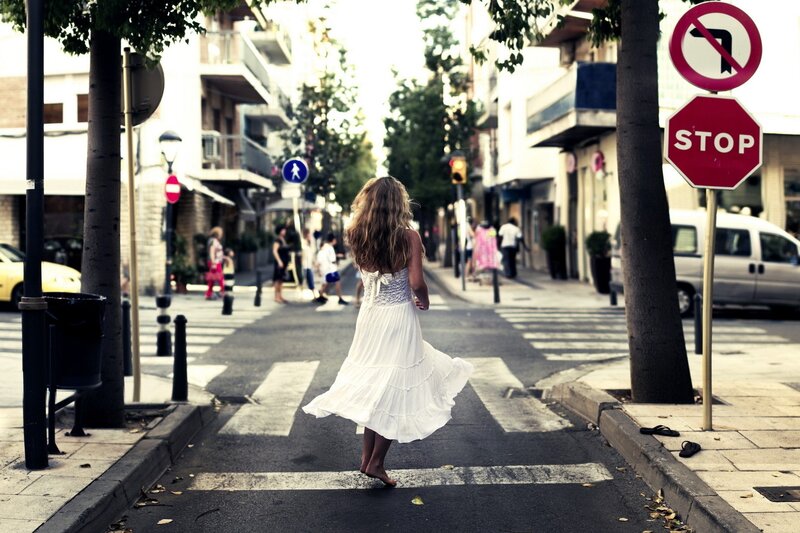 Woman in white dress crossing street