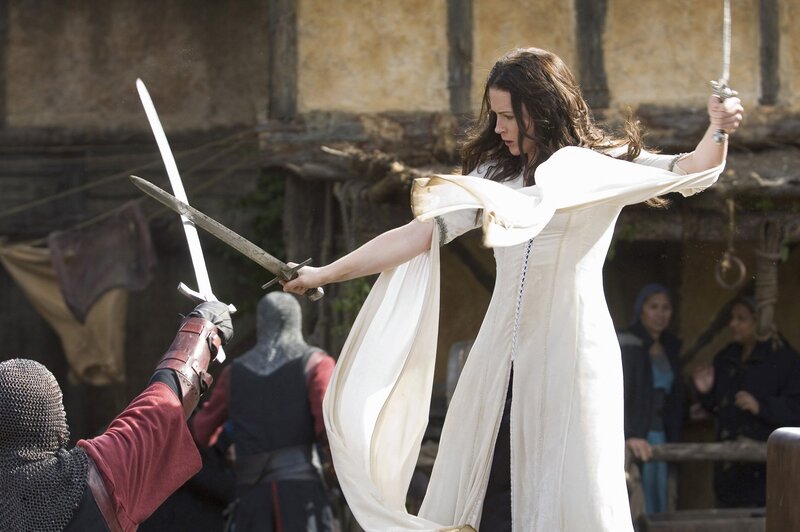 Woman in white dress fighting with swords