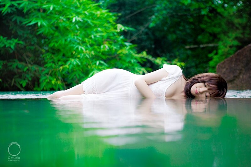 Woman in white dress floating in water