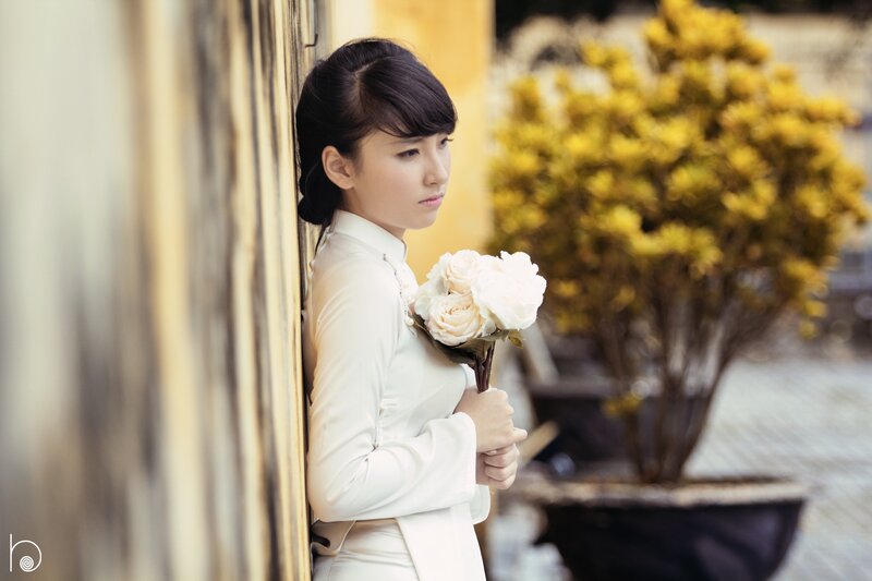 woman in white dress holding flowers