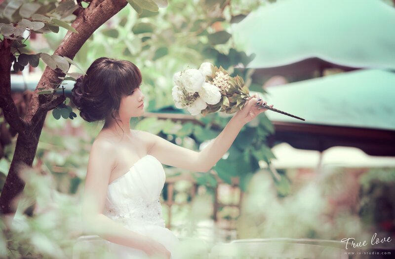 woman in white dress holding flowers