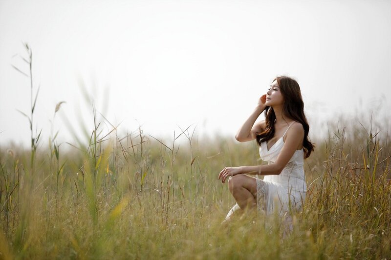 Woman in white dress in field