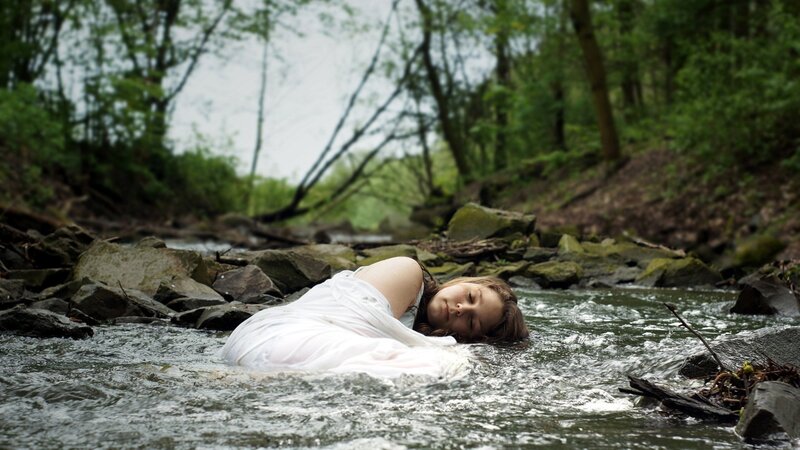 Woman in white dress in stream