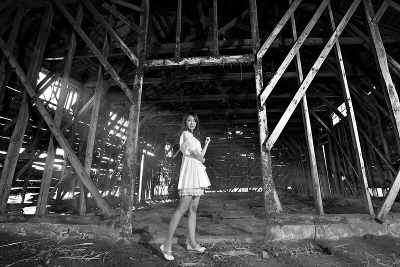 Woman in white dress inside barn