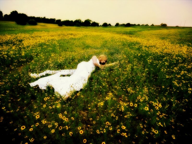 woman in white dress lying in field