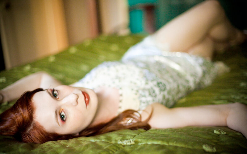 Woman in white dress lying on bed