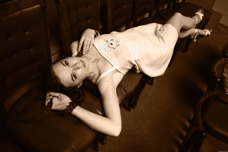 woman in white dress lying on chair