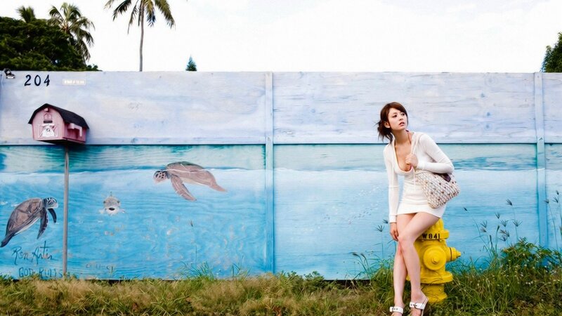 Woman in white dress near mural