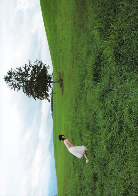 Woman in white dress on a green hill