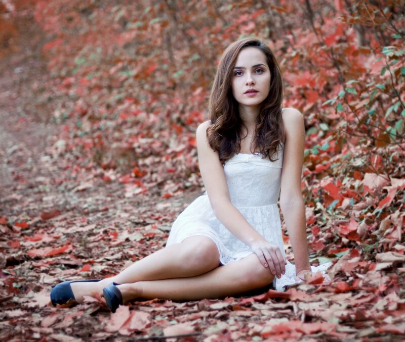 Woman in white dress on autumn leaves
